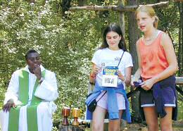 photo of Fr. Paul Arinze listening to two Camp Gray campers