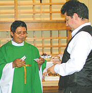 photo of Fr. Abdón Ortiz presenting catechist Jorge Miramontes with certificate, cross, and pin
