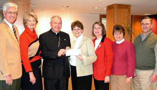 photo of Bishop Morlino giving Diocese of Madison contribution for The Elizabeth House to Liz Osborn and others