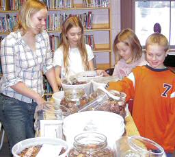 photo of four St. John School, Princeton, students with money the school raised for tsunami relief through a 'penny war'