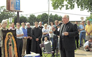 photo of Bishop Robert C. Morlino talking to crowd gathered on sidewalk outside Planned Parenthood Clinic on Madison's east side during the pro-life vigil for an end to abortion