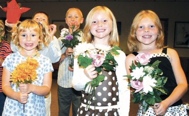 photo of students at St. Joseph School in Dodgeville getting ready to process into church with flowers during a living Rosary