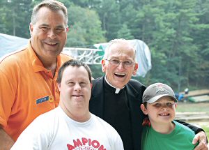 photo of Tom Diehl, back left, Tommy Bartlett show president, and Msgr. Thomas Campion, director of the Apostolate to the Handicapped, with Scott Peters of Chicago, Ill., left, and Jacob Hawkinson of Monroe, at the Apostolate summer outing