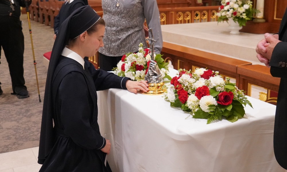 Religious sister venerating a relic of St. John Paul II