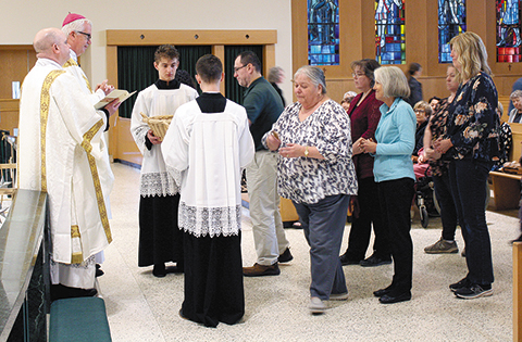 Bishop Donald J. Hying of Madison presents crosses at the Go Make Disciples Commissioning Mass on May 20 at Immaculate Heart of Mary Church in Monona. (Catholic Herald photo/Julia Kloess)
