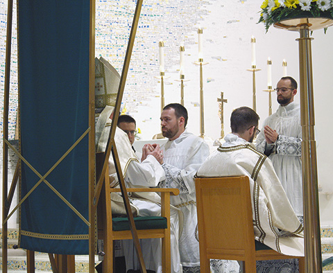 Transitional Deacon David Drefcinski promises obedience to Bishop Donald J. Hying of Madison and his successors during the Ordination Mass at Immaculate Heart of Mary Church in Monona on May 12. Transitional Deacon Anthony Kersting, right, looks on. (Catholic Herald photo/Julia Kloess)