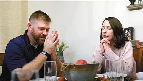 Matt and Sherri Piekarski pray at their dinner table in the short film, Dare to Believe | The Eucharist. (Screenshot from Dare to Believe | The Eucharist)